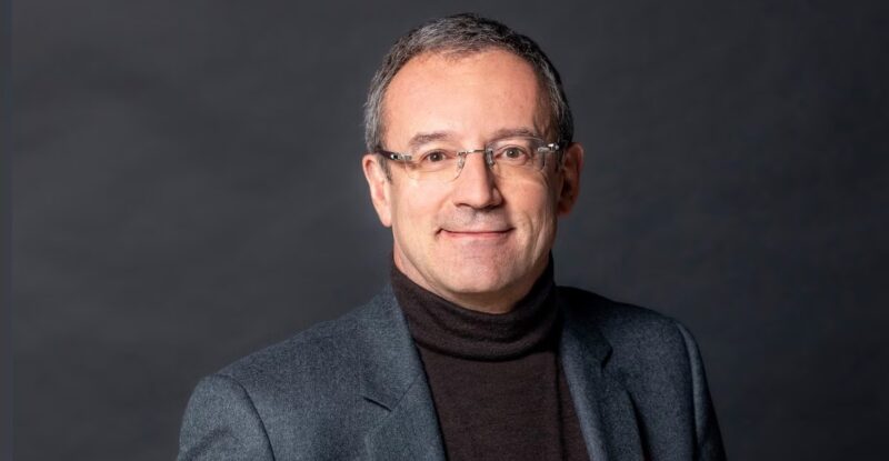 Eutelsat CEO Jean-François Fallacher is pictured in a suit, against a grey background.